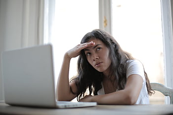 Young woman expressing frustration while working remotely on her laptop at home. HD wallpaper