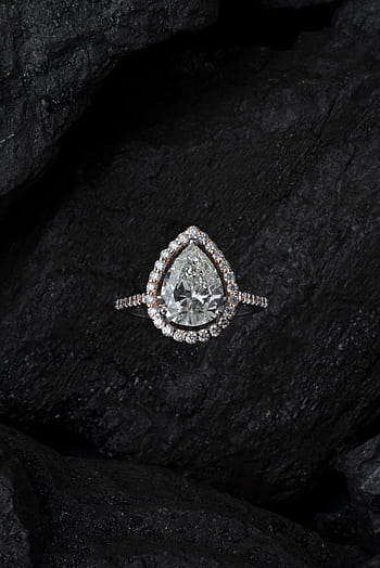 Stunning teardrop diamond ring surrounded by smaller stones on a textured dark background. HD phone wallpaper