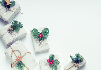 Minimalist Christmas gift boxes adorned with natural elements like pine branches and twine, perfect for holiday inspiration. HD wallpaper