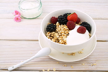 Delicious granola bowl topped with fresh berries and yogurt, perfect for a healthy breakfast. HD wallpaper