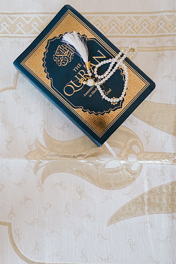 Top view of an elegant Quran and prayer beads on ornate white cloth, symbolizing Islamic faith. HD phone wallpaper