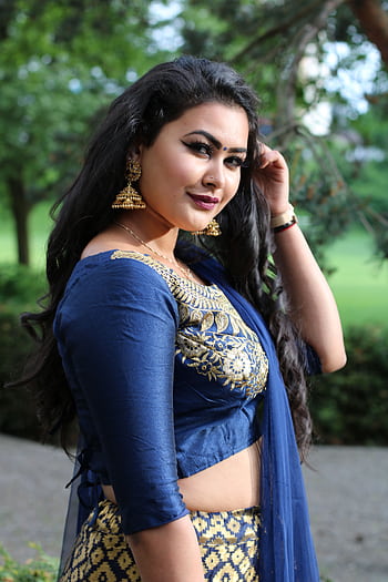 Portrait of a woman in traditional blue attire with gold jewelry, posing outdoors. HD phone wallpaper