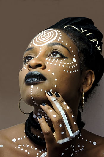 Striking portrait of a woman adorned with intricate tribal face paint and accessories. HD phone wallpaper