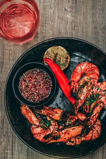 Close-up of spicy grilled shrimp with dipping sauce and grilled lime slice on a plate. HD phone wallpaper