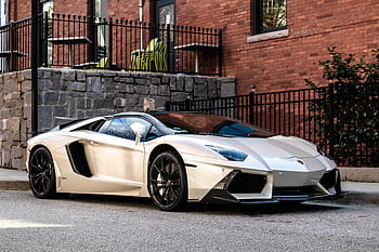Elegant white sports car parked on a city street in Atlanta, showcasing luxury design. HD wallpaper