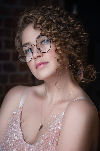 Elegant portrait of a woman wearing eyeglasses and adorned with jewelry, highlighting a modern fashion style. HD phone wallpaper