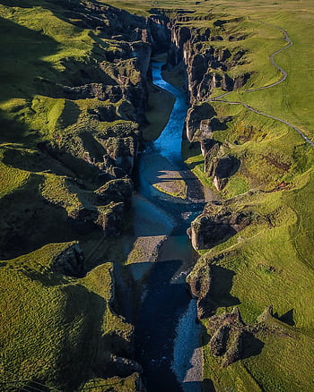 Stunning aerial graph of a canyon in Iceland, showcasing rugged cliffs and a winding river. HD phone wallpaper