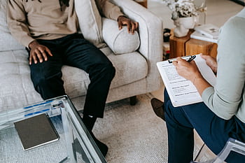 An engaging therapy session with a professional counselor listening attentively to a client indoors. HD wallpaper