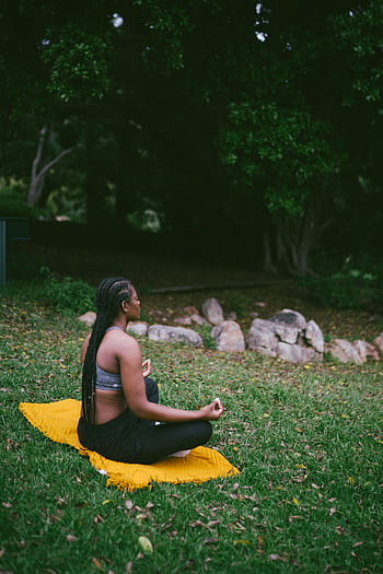 A woman meditating on a yellow mat in a serene outdoor setting. HD phone wallpaper