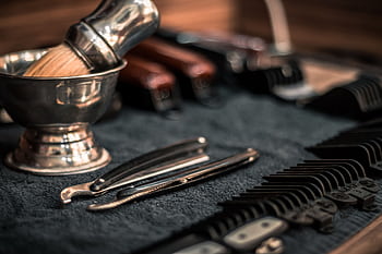 Close-up of neatly arranged barber tools, including razors and combs, highlighting precision. HD wallpaper