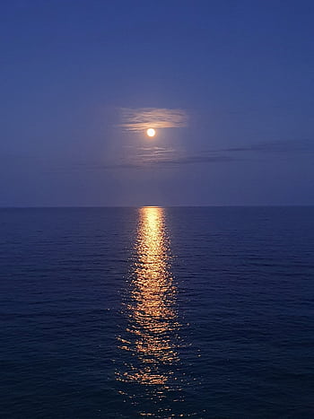 Serene ocean view with full moon reflection at night, creating a peaceful atmosphere. HD phone wallpaper