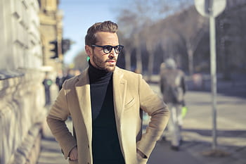 Stylish man in glasses and coat posing outdoors on an urban street in Budapest. HD wallpaper
