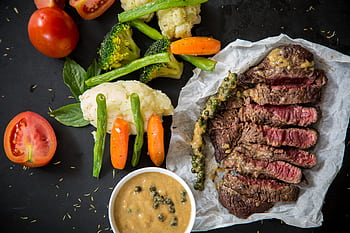 Grilled steak served with fresh vegetables and pepper sauce, presenting a colorful and appetizing meal. HD wallpaper