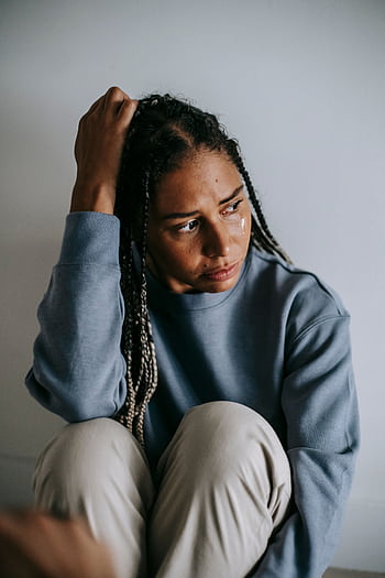 An adult woman in a contemplative state expressing emotion and reflection indoors. HD phone wallpaper