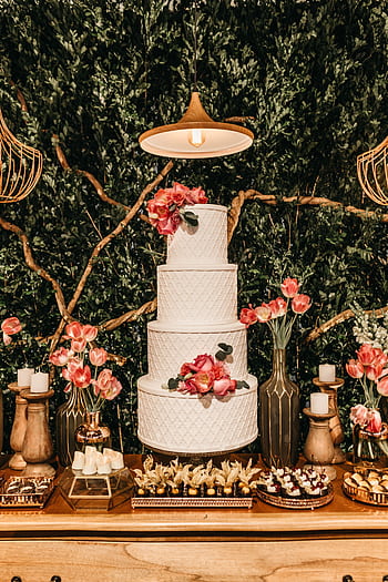 A beautifully decorated wedding table featuring a three-tiered cake, flowers, and desserts in a romantic setting. HD phone wallpaper