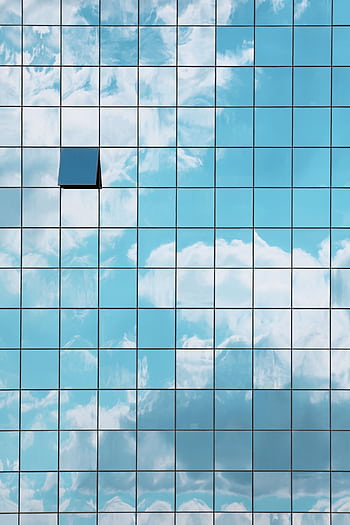 A modern skyscraper facade reflecting a blue sky with clouds and an open window revealing contrast. HD phone wallpaper