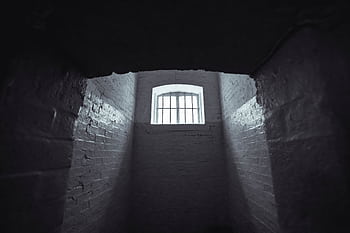 Moody shot of an abandoned prison cell in Hong Kong with dim lighting and shadowy walls. HD wallpaper