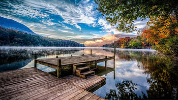 Wood Dock On Lake Colorful Leaves Autumn Trees Mountain Background With Fog Under White Clouds Blue Sky Reflection On Water Nature HD wallpaper