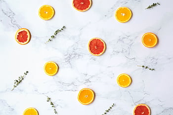 Artistic flatlay of orange and grapefruit slices on a marble background with herbs. Perfect for food styling. HD wallpaper