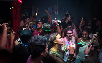 Lively nightclub scene with a vibrant crowd dancing energetically under colorful lights. HD wallpaper