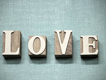 Wooden block letters spelling 'love' on a textured blue background, ideal for creative projects. HD wallpaper