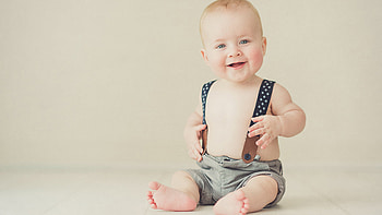 Smiley Grey Eyes Cute Baby Boy Is Sitting On Floor In Wall Background Wearing Shorts Cute HD wallpaper