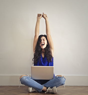 Happy woman with laptop, celebrating success indoors. Arms raised in triumph. HD phone wallpaper