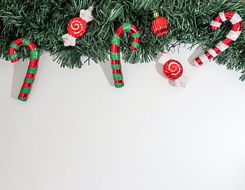 Christmas-themed with candy canes and ornaments on greenery, perfect for holiday decorations. HD wallpaper