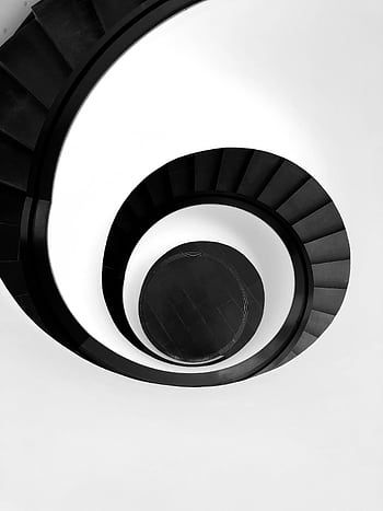 Black and white abstract of a spiral staircase in Nürnberg, Germany showcasing minimalism and modern architecture. HD phone wallpaper