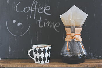 A cozy café scene featuring a Chemex with freshly brewed coffee and a patterned mug, perfect for morning rituals. HD wallpaper