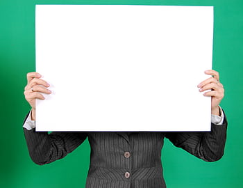 An individual in a formal blazer holds a blank whiteboard, ideal for custom messages. HD wallpaper