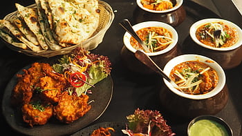 A mouth-watering display of Indian cuisine featuring naan, curry, and pakoras perfect for a delightful meal. HD wallpaper