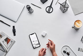 Flat lay of a modern workspace featuring tech devices, a latte, and office supplies. HD wallpaper