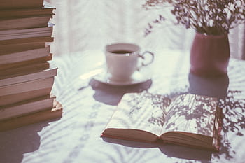 A serene scene featuring books, a coffee cup, and shadows creating a cozy ambiance. HD wallpaper