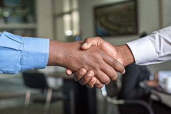Close-up of two men's handshake symbolizing agreement in an office. HD wallpaper