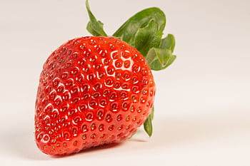 Bright and juicy strawberry close-up highlighting freshness on a white background. HD wallpaper