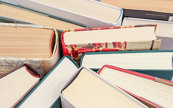 A vibrant collection of hardcover books with colorful covers viewed from above. HD wallpaper