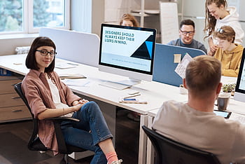 Team of young professionals collaborating in a modern office, fostering creativity and innovation. HD wallpaper