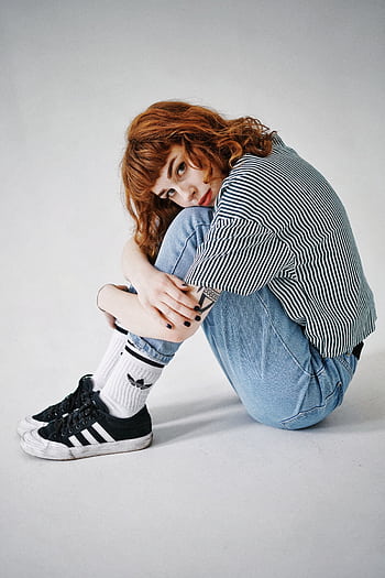 Red-haired woman in casual jeans and stripes, posing indoors with a confident style. HD phone wallpaper