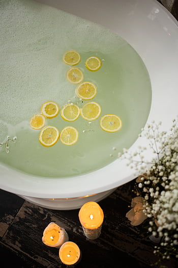 Relaxing bathtub with lemon slices and candles for a soothing spa experience. HD phone wallpaper