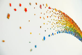 Vibrant abstract rainbow art with colorful shapes on a white wall, perfect for creative backgrounds. HD wallpaper