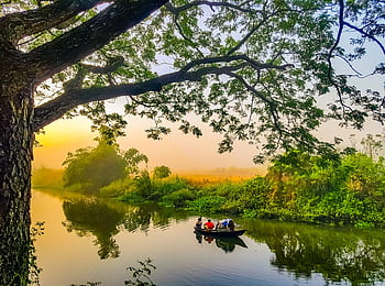 Peaceful boat ride during sunrise at Gazaria, capturing the lush landscape and tranquil river. HD wallpaper