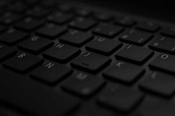 A detailed close-up of a black laptop keyboard with soft lighting and selective focus. HD wallpaper