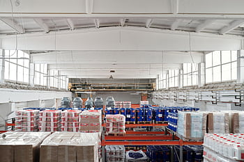 Spacious warehouse interior featuring organized shelves with various stacked pallets. HD wallpaper