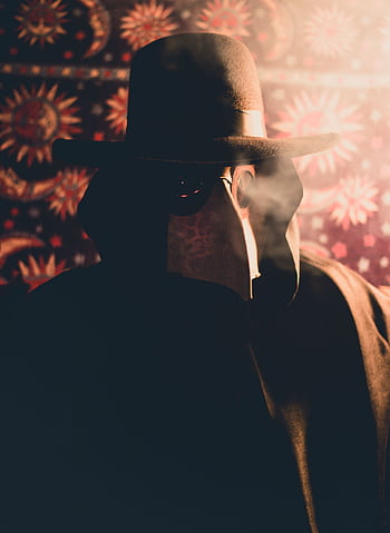 A mysterious figure in a plague doctor costume enveloped in smoke with a dark, creepy atmosphere. HD phone wallpaper