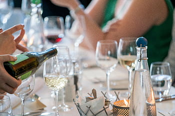 A sophisticated dinner setting with a focus on wine pouring creates a luxurious dining ambiance. HD wallpaper