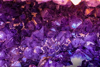 Close-up view of a beautiful amethyst crystal cluster showcasing its vibrant purple hues and natural texture. HD wallpaper