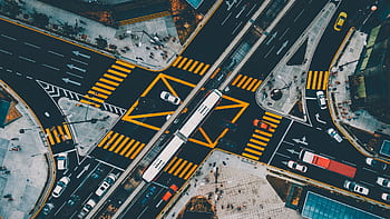 Dynamic aerial shot capturing a busy urban intersection in Kuala Lumpur with vibrant traffic and pedestrians. HD wallpaper