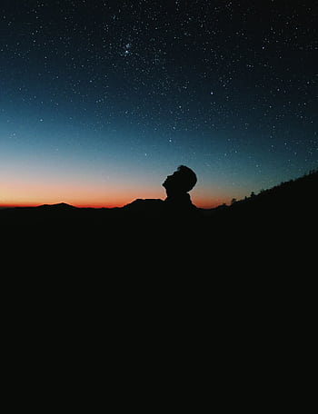 A person silhouetted against a vibrant starry sky, capturing the essence of night and tranquility. HD phone wallpaper