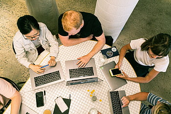 Top view of diverse team collaboratively working in a modern office setting. HD wallpaper